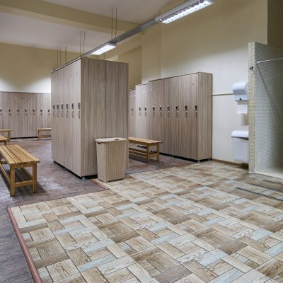 Public shower interior with everal showers, toilet sink and lockers in locker room in luxury fitness spa centre